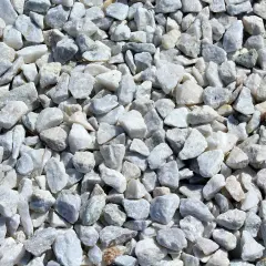 Duża ilość białego, szarego i lekko zielonkawego kruszywa drogowego.