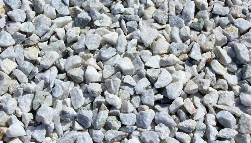 Duża ilość białego, szarego i lekko zielonkawego kruszywa drogowego.