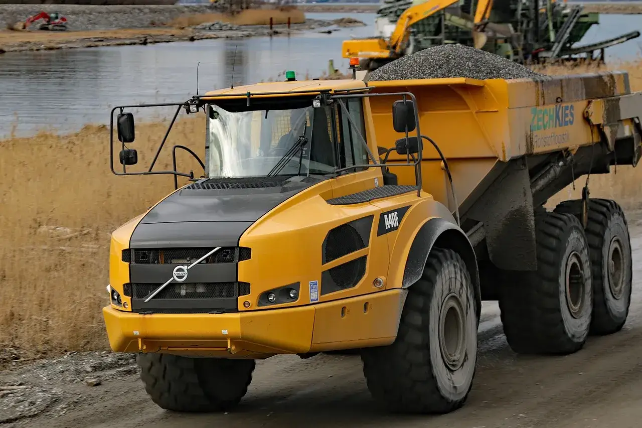Żółta wywrotka Volvo z naczepą pełną żwiru. Zastanawiasz się, ile kosztuje wywrotka żwiru? Ta maszyna jest gotowa do pracy.